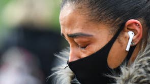 A woman cries at a memorial site at the Clapham Common Bandstand