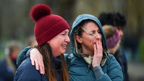 People mourn at a memorial site