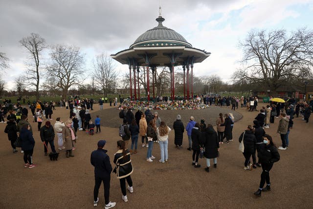People gather at a memorial site in Clapham Common Bandstand