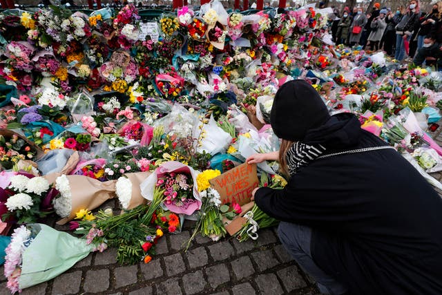 A woman leaves a floral tribute