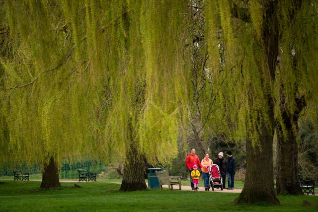 A family walks in St Nicholas' Park in Warwick, the hot weather which baked much of the UK this week is set to give way to a chilly Easter weekend. 