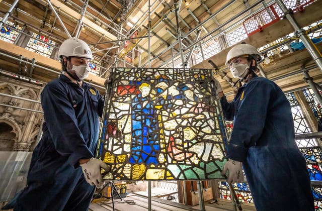 York Glaziers Trust 的员工 Kieran Muir (剩下) 和艾米丽·普莱斯 (正确的) 在新的五年开始时拆除彩色玻璃窗板, 耗资 500 万英镑的项目，用于保护约克大教堂的东南 Transept 及其中世纪的圣卡斯伯特窗