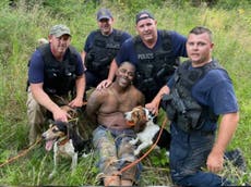 Anger as armed white police officers with dogs pose with captured Black suspect