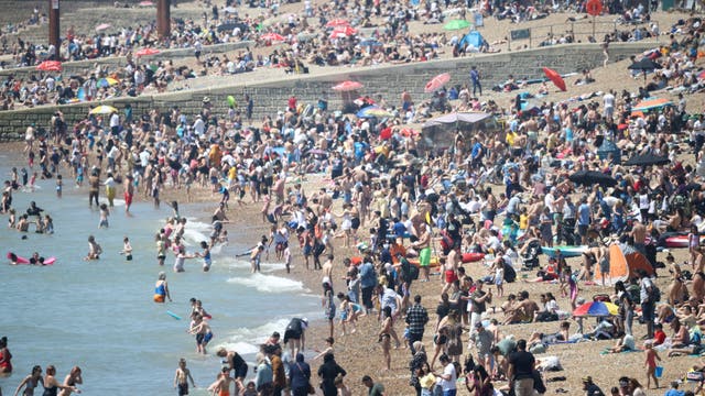 人々はブライトンビーチで暑い天気を楽しんでいます
