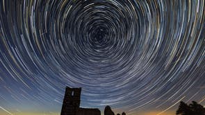 Une photographie à longue exposition capture la rotation de la terre alors que les étoiles se fondent en cercles au-dessus des ruines de l'église de Knowlton dans le Dorset