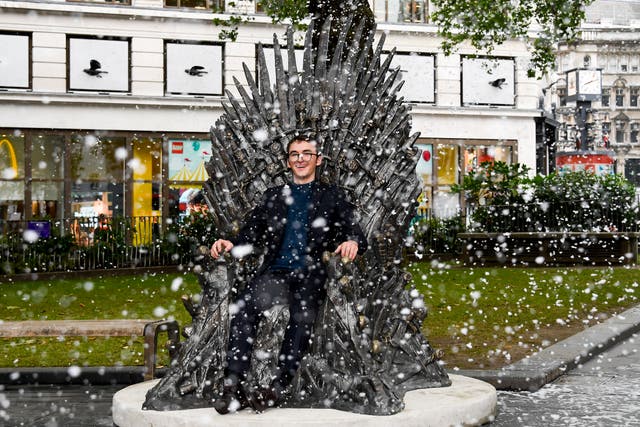 Actor Isaac Hampstead Wright sits on the newly unveiled Game of Throne's "Iron Throne" statue, in Leicester Square, in London, Tuesday, June 22, 2021. The statue is the tenth to join the trail and commemorates 10 years since the TV show first aired, as well as in anticipation for HBO's release of House of the Dragon set to be released in 2022
