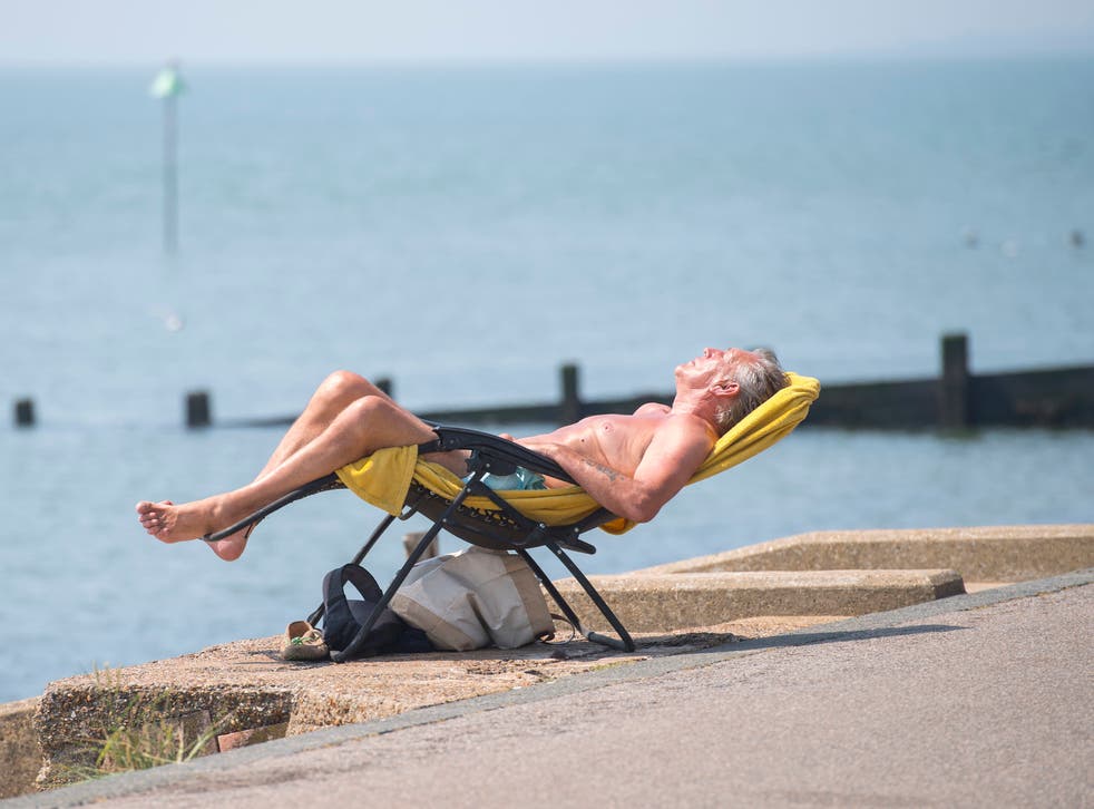 <p>People enjoy the sun on Southend beach in Essex during a UK heatwave</磷>