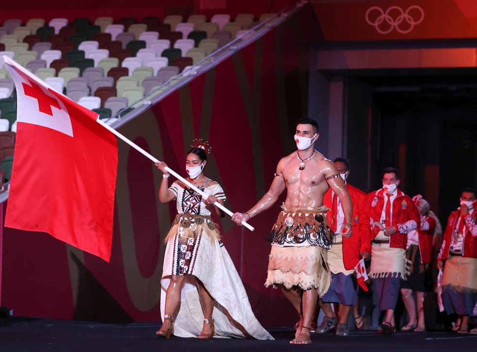 <p>Pita Taufatofua, pictured on the right leading the Tongan team out during the Opening Ceremony of the Tokyo 2020 Olympic Games, has been unable to contact his loved ones since the natural disaster. </p>