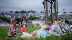  一个女人和两个年轻女孩在普利茅斯观看鲜花致敬，那里有六个人, 包括罪犯, 在枪械事件中死于枪伤 