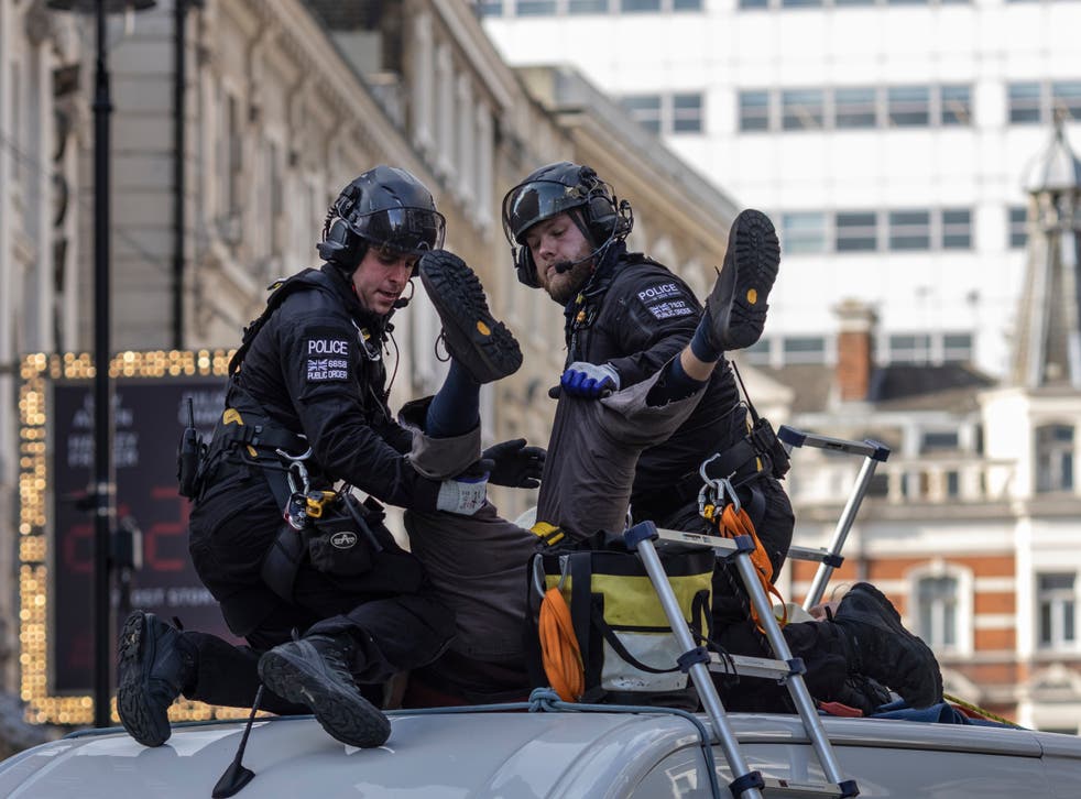 <p>An XR protester, who installed himself on top of a van near Covent Garden, is arrested by police</p>