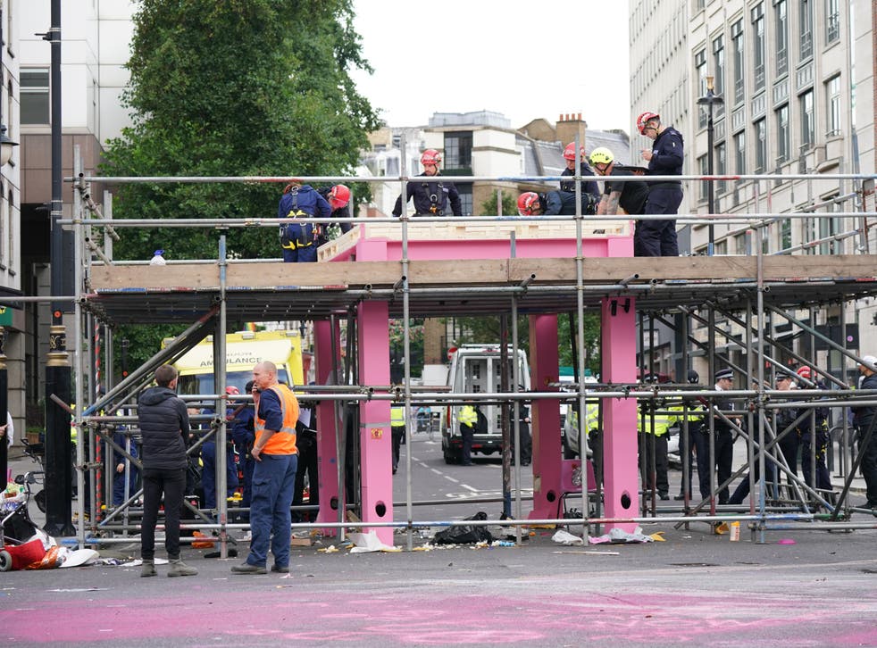 <p>Workers remove the table, which was blocking the junction of Long Acre and Upper St Martin’s Lane, on Tuesday morning</p>