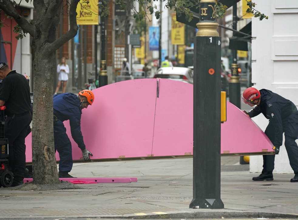 <p>Part of the table’s top, on which XR protesters sat yesterday, is carried off by workers, watched over by police</p>