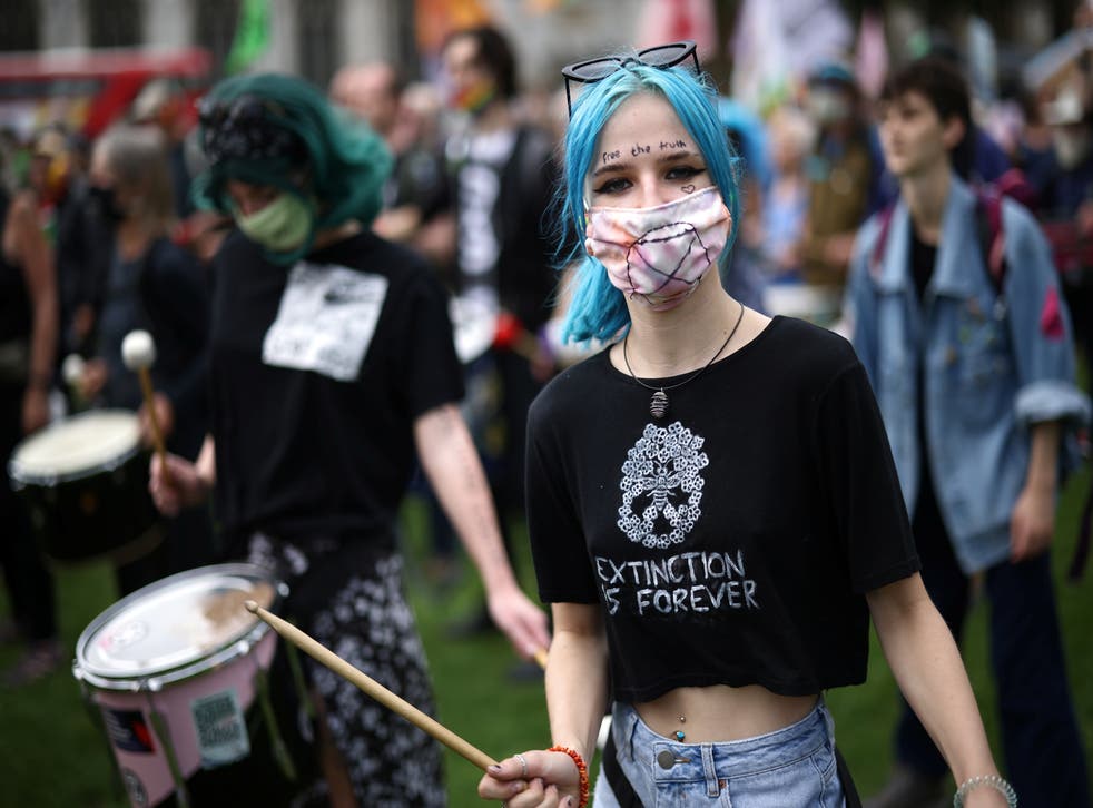 <p>A protester holding a drum stick reacts during the protest today</p>