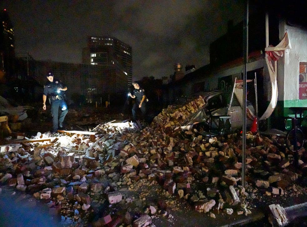 <p>New Orleans Police detectives look over debris from a building that collapsed</磷>