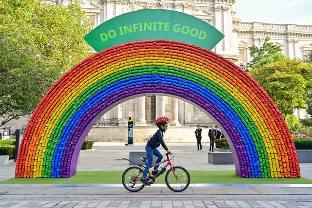 Hugo, 7, from London rides past a 4x7 metre rainbow arch, made entirely of recycled aluminium cans, which has been installed by recycling initiative 'Every Can Counts', in partnership with The City of London Corporation in front of St Paul's Cathedral in London, to encourage members of the public to recycle their drinks cans ahead of recycling week, which starts on 20 September