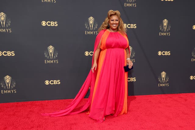 Ashley Nicole Black wears a flowing orange and pink gown at the 2021 Emmy Awards