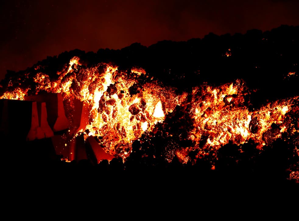 <p>Lava flows downhill following the eruption of a volcano in the Cumbre Vieja national park at El Paso</s>