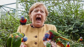German Chancellor Angela Merkel feeds Australian lorikeets at Marlow Bird Park in Marlow, Tyskland