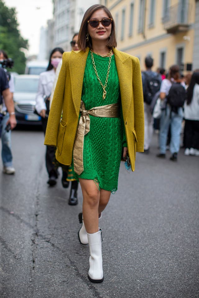 Cette robe chemise en tricot vert gazon était accessoirisée de bijoux en or et de bottes blanches