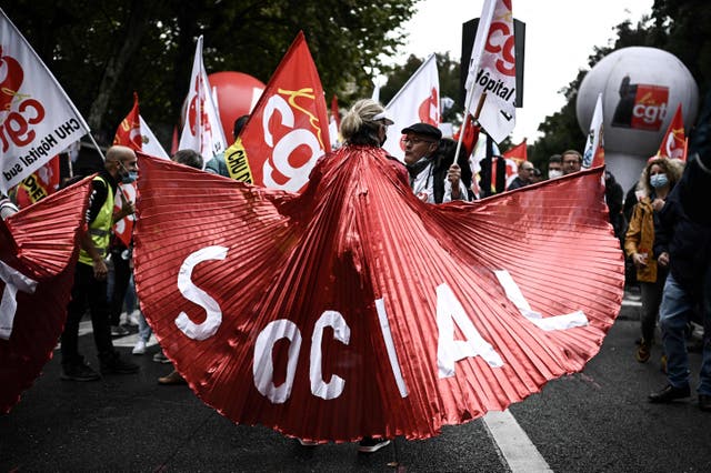 女性はバナーを読んで保持します "ソーシャル" 人々がより良い労働条件のための全国的な一日の一部としてフランスの労働組合によって呼び出されたデモに参加するように