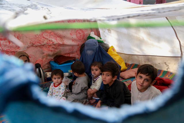 Afghan children who were displaced from other parts of the country live in temporary shelters at a camp in Kabul, Afeganistão,
