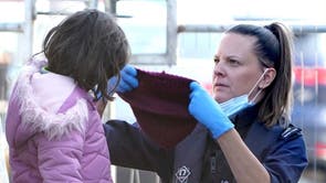 Une jeune fille est aidée par un officier des forces frontalières alors qu'un groupe de personnes soupçonnées d'être des migrants est amené à Douvres, Kent, suite à un incident de petit bateau dans la Manche. 