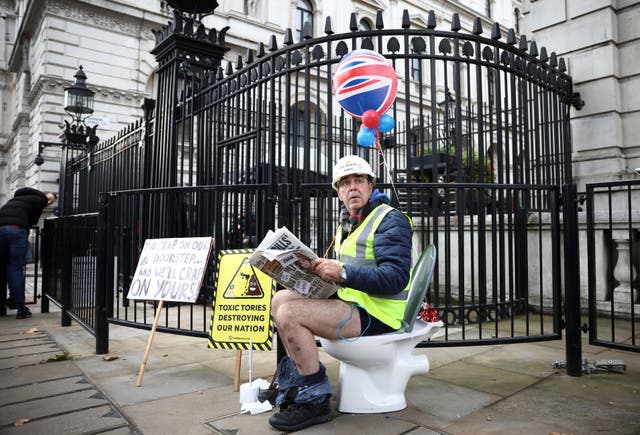 Aktivisten Steve Bray demonstrerer med et toalett utenfor portene til Downing Street, etter at parlamentsmedlemmer stemte i parlamentet mot miljølovforslaget, tillater selskaper å pumpe råkloakk til elver og hav i Storbritannia,  i London