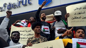 レバノンに住むスーダンの抗議者たちは、ベイルートのスーダン大使館の前でスーダンの人々との連帯を示すために、抗議中にプラカードを持ってスローガンを叫びます。