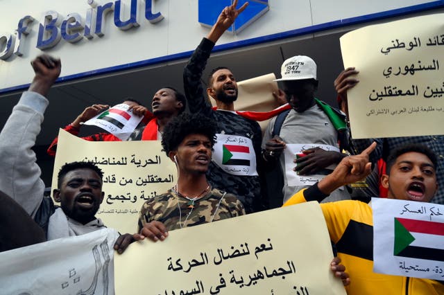 Sudanese protesters living in Lebanon carry placards and shout slogans during a protest to show solidarity with the Sudanese people in front of the Sudanese embassy in Beirut