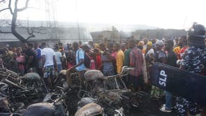 Les gens regardent un tas de motos brûlées à la suite de l'explosion d'un camion-citerne à Freetown