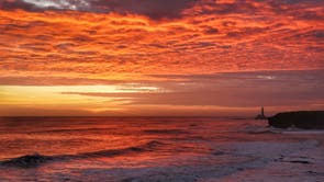 Nascer do sol sobre o Farol de Santa Maria em Whitley Bay, na costa nordeste da Inglaterra