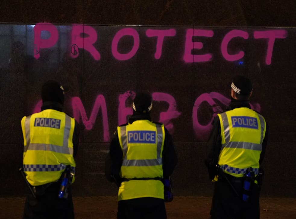 <p>Police officers stand in front of a branch of Santander on St Vincent Street, Glasgow, where graffiti has been sprayed on the wall, as Extinction Rebellion protest outside. </bl>