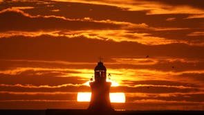 The sun rises over South Shields Lighthouse, on the North East coast of England