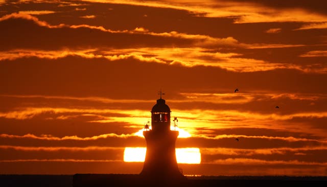 O sol nasce sobre o farol de South Shields, na costa nordeste da Inglaterra