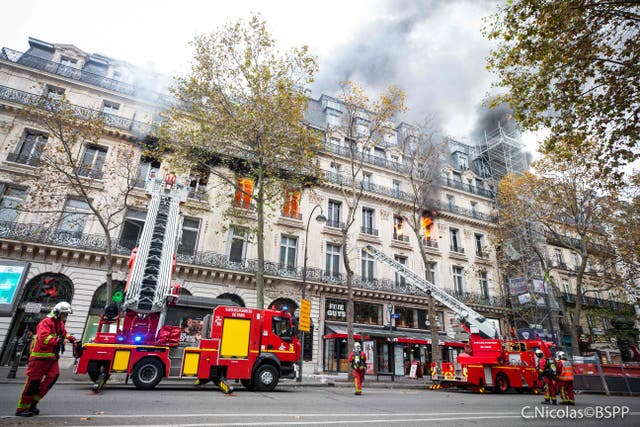 De la fumée et des flammes s'échappent d'un immeuble alors que les pompiers sont intervenus pour éteindre l'incendie du boulevard des Capucines à Paris