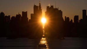 Le soleil se lève au-dessus de la 42e Rue lors d'un 'Manhattanhenge' inversé à New York, New York photographié depuis Weehawken, New Jersey. « Manhattanhenge » est un phénomène au cours duquel le soleil couchant ou le soleil levant est aligné avec les rues est-ouest de la grille des rues principales de Manhattan, La ville de New York. 