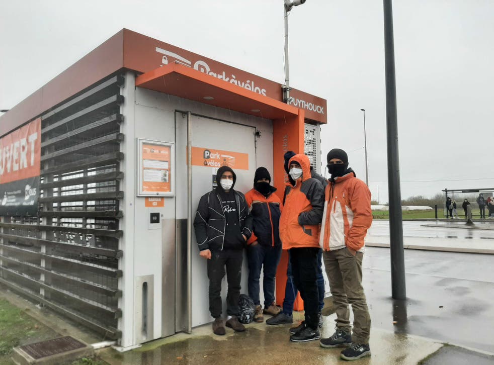 <p>A group from Iran attempt to shelter from the rain in Dunkirk while contemplating an attempt to cross the Channel</p>