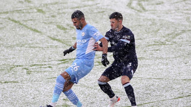 Riyad Mahrez fra Manchester City kjemper om besittelse med Aaron Cresswell fra West Ham United under en kamp på Etihad under snø
