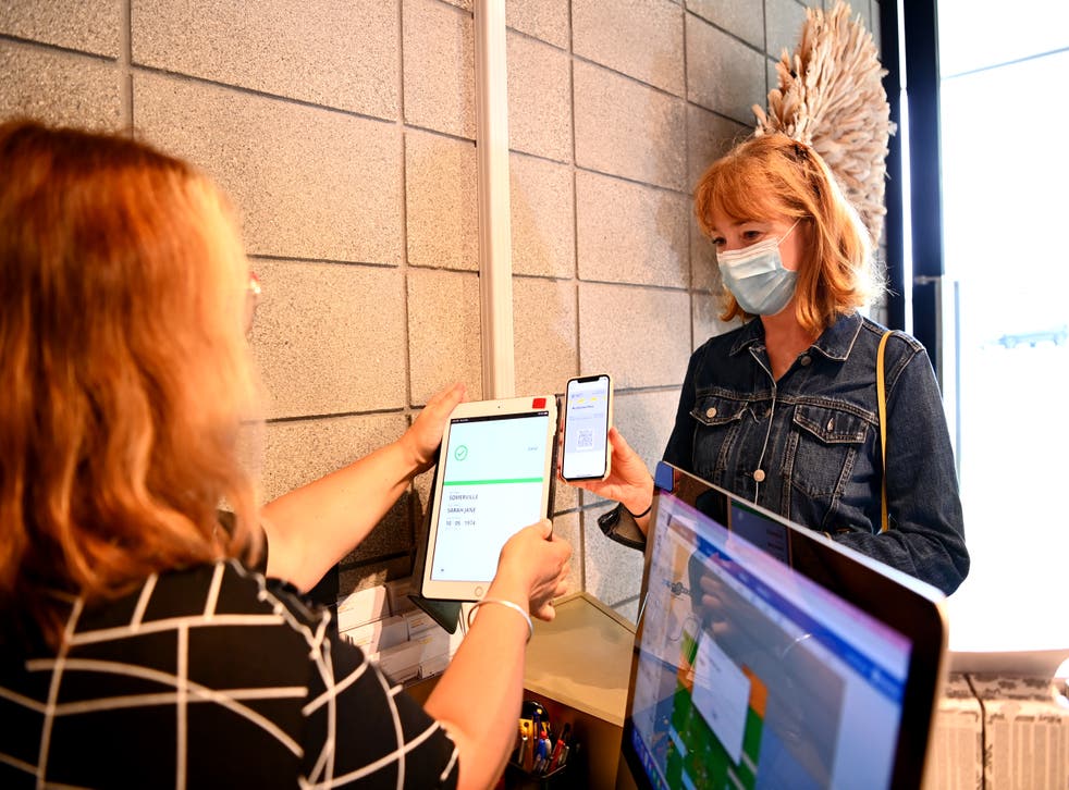 <p>A client scans in her vaccine passport at Luxe & Duke Hairdressing on 25 November 2021 in Auckland, New Zealand</p>