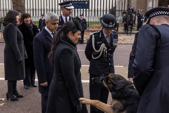 Priti Patel, minister van binnelandse sake, word gegroet deur 'n polisiehond by 'n spesiale gedenkdiens vir Met-polisiesersant Matiu Ratana