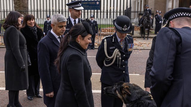 Innenriksminister Priti Patel blir møtt av en politihund ved en spesiell minnegudstjeneste for Met Police Sergeant Matiu Ratana
