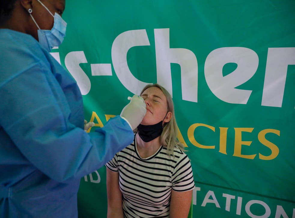 <p>A healthcare worker conducts a polymerase chain reaction (PCR) Covid-19 test on a traveller at OR Tambo International Airport in Johannesburg on 27 November 2021</p>