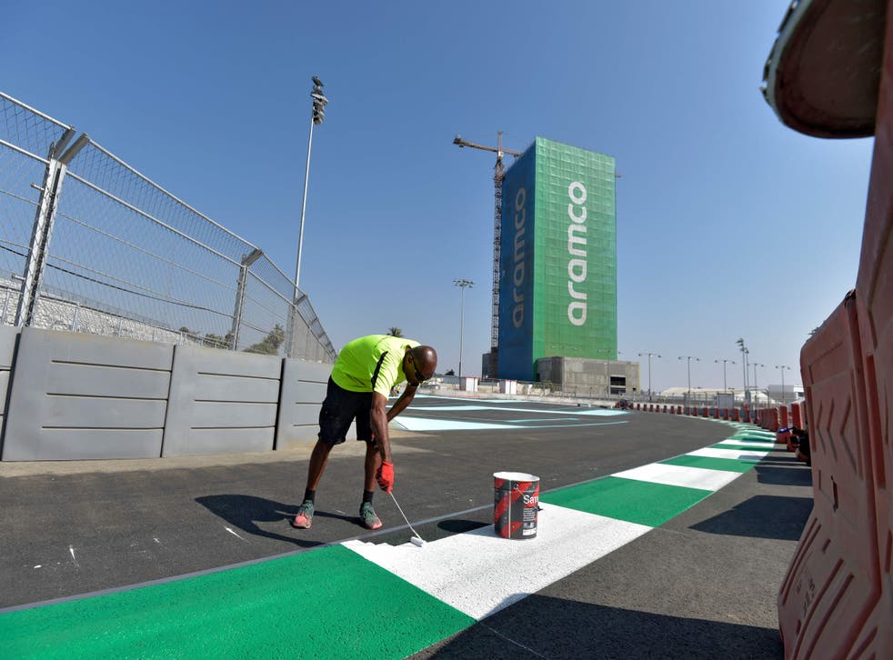 <p>Workers put the final lick of paint on the Jeddah Corniche Circuit</p>