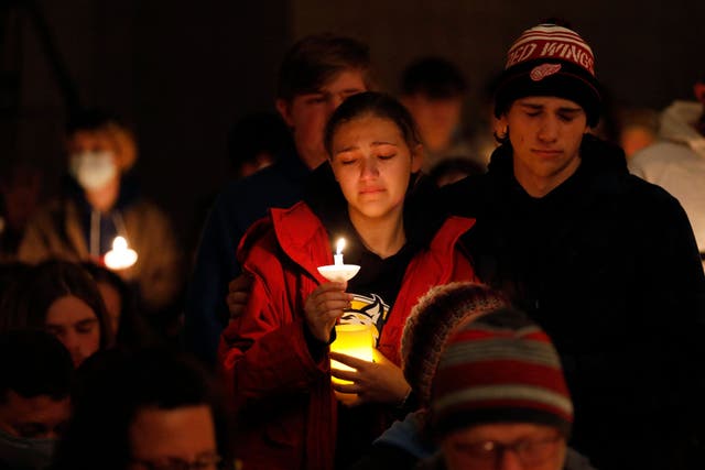 Oxford High students holding candles become emotional as they are asked to stand during a vigil after a shooting at Oxford High School at Lake Pointe Community Church in Lake Orion, Michiga
