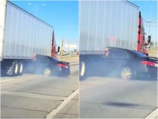 Horror video shows truck drag car down highway as driver waves for help