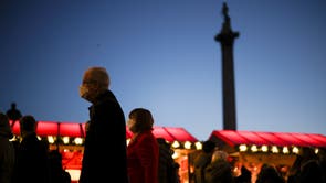 Mense stap deur 'n Kersmark in Trafalgar Square