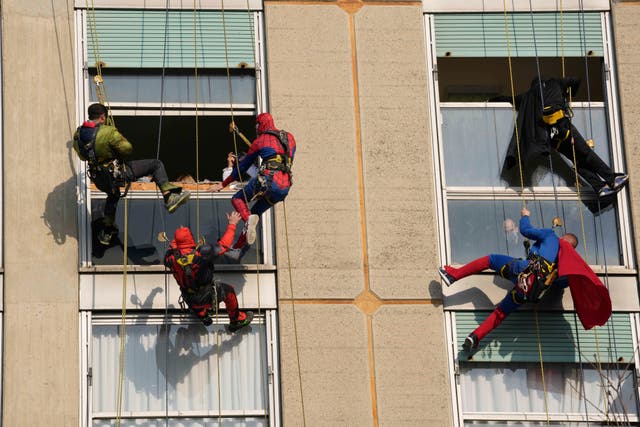 Acrobats dressed as superheroes make a surprise greeting at the windows of children at the San Paolo hospital in Milan, Italië