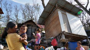 Residents stand amid damaged homes following Typhoon Rai in Talisay, Cebu province, central Philippines