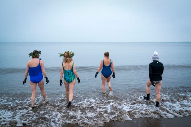 人们在爱丁堡的波托贝罗海滩参加冬至游泳，以纪念冬至并见证一年中最长的夜晚之后的黎明