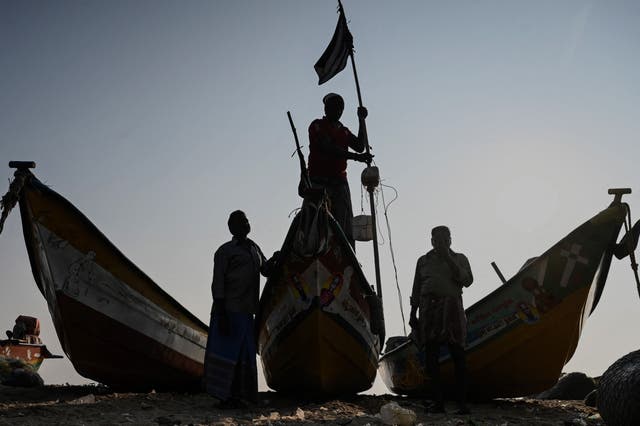 A fisherman ties up a black flag on his boat to pay homage to the victims of the 2004 tsunami at Pattinapakkam Beach in Chennai, インド